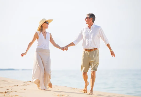 Casal de meia-idade desfrutando de caminhada na praia — Fotografia de Stock