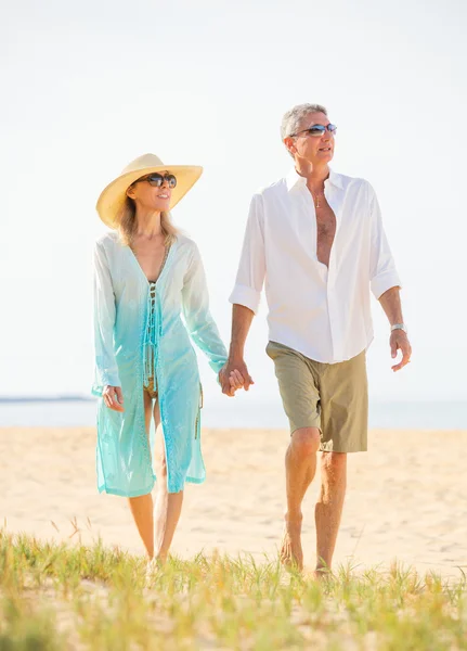 Midden leeftijd paar genieten van wandelen op het strand — Stockfoto