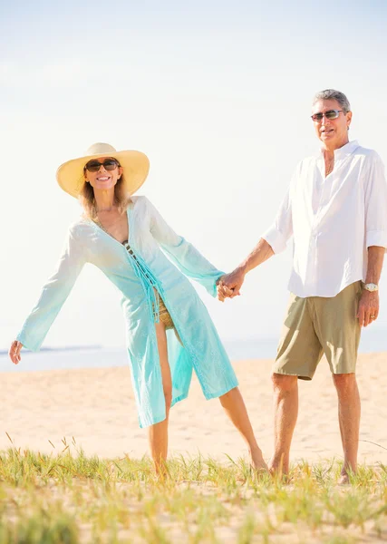 Pareja de mediana edad disfrutando de un paseo por la playa — Foto de Stock