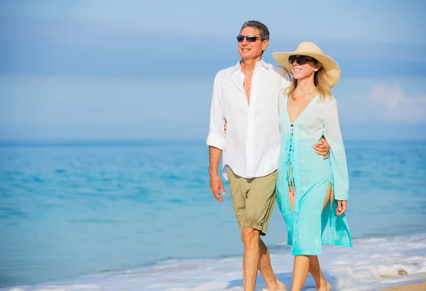 Mellersta åldern par njuter av promenad på stranden — Stockfoto