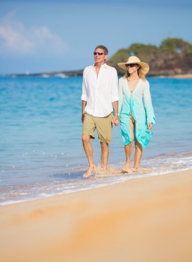 Kumsalda yürüyen romantik bir çift.