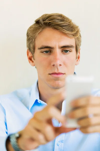 Genç profesyonel, yakışıklı bir adam akıllı cep telefonu kullanma — Stok fotoğraf