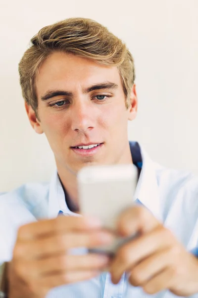 Genç yakışıklı bir adam akıllı cep telefonu kullanma, — Stok fotoğraf