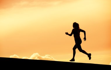 gün batımına doğru çalışan kadın atlet siluet