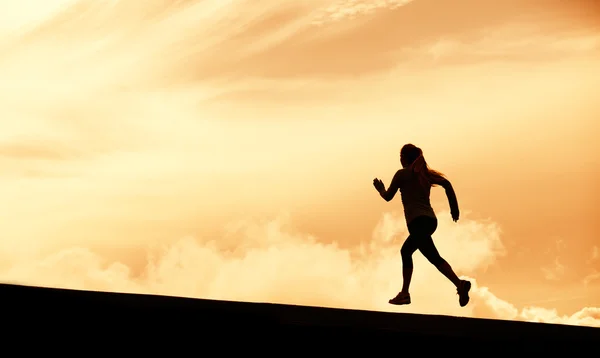 Silueta de corredor femenino, corriendo hacia el atardecer —  Fotos de Stock