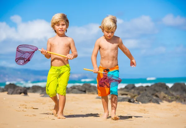 Dos chicos jóvenes divirtiéndose en la playa tropcial — Foto de Stock