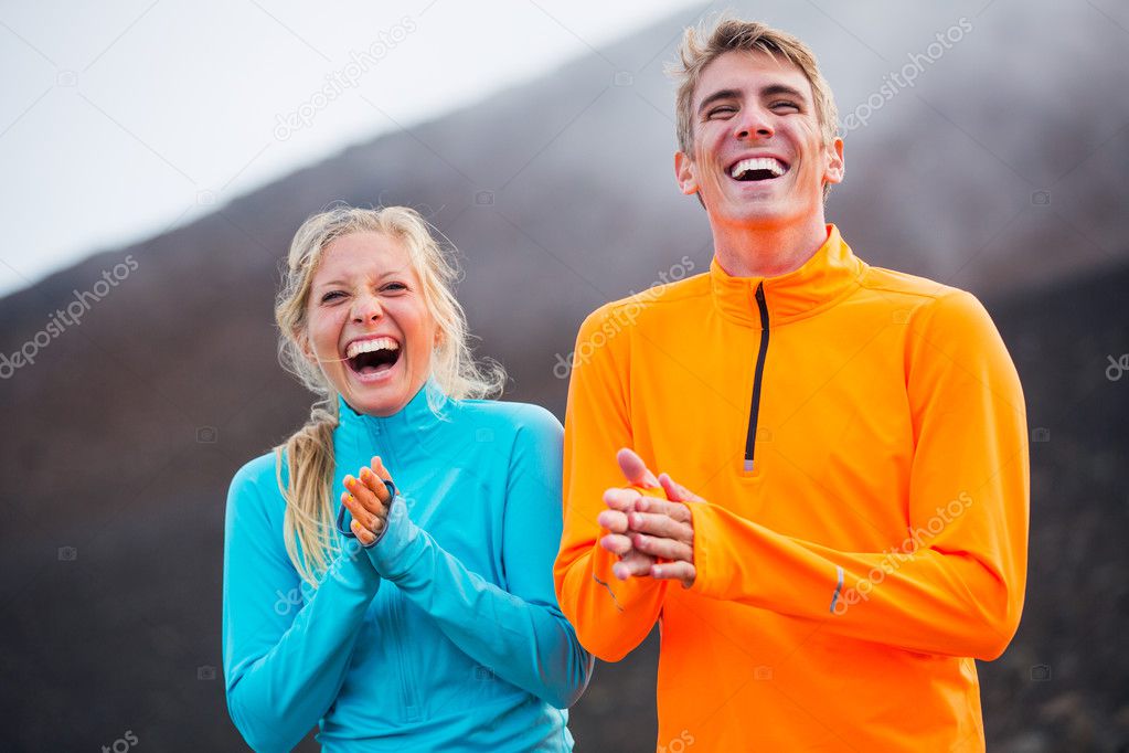 Young attractive athletic couple, wearing sporty cloths on trail