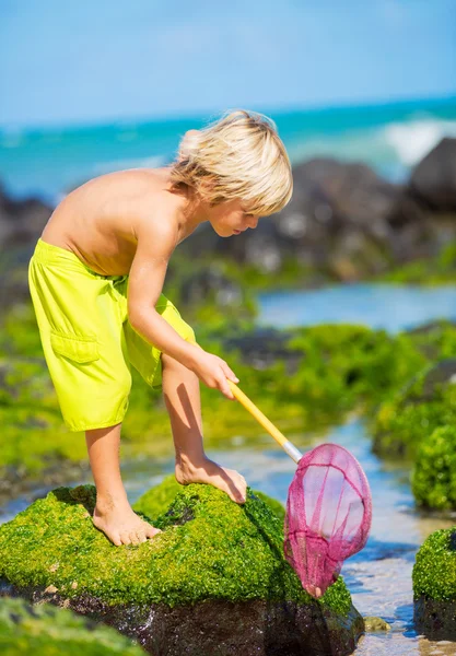 Felice Giovane ragazzo divertirsi in spiaggia, giocando con la pesca ne — Foto Stock