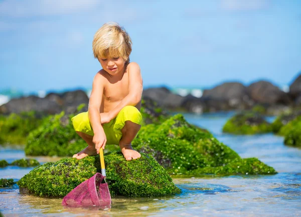 Felice Giovane ragazzo divertirsi in spiaggia, giocando con la pesca ne — Foto Stock