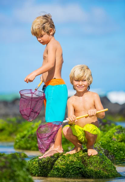 Niños jóvenes y felices jugando en la playa en las vacaciones de verano — Foto de Stock