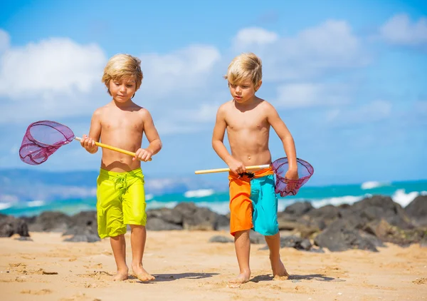 Jovens crianças felizes brincando na praia em férias de verão — Fotografia de Stock