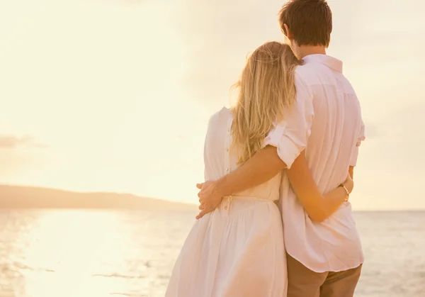 Happy romantic couple on the beach at sunset embracing each othe — Stock Photo, Image