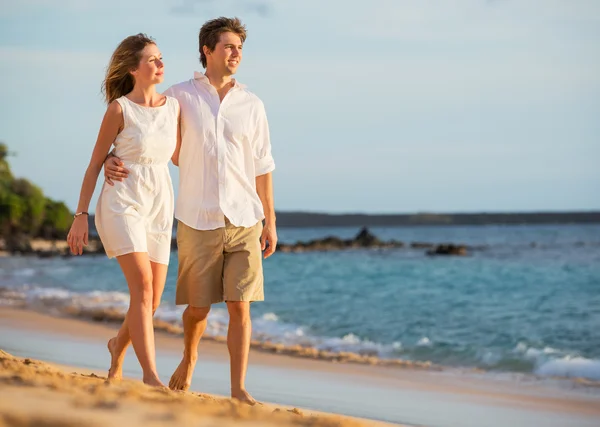 Romantic happy couple walking on beach at sunset. Smiling holdin — Stock Photo, Image
