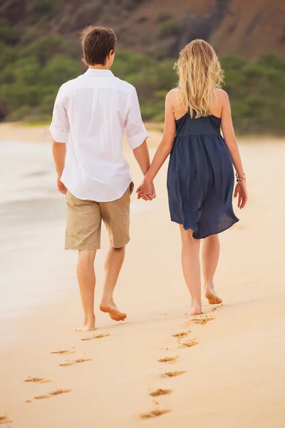Couple heureux romantique marchant sur la plage au coucher du soleil. Tenue souriante — Photo