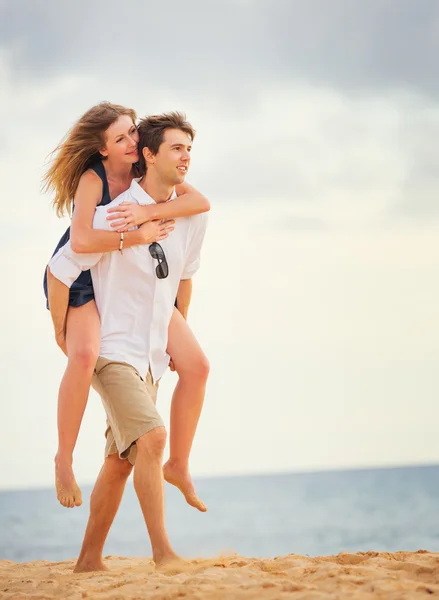 Romantique couple heureux sur la plage au coucher du soleil, homme et femme en l — Photo