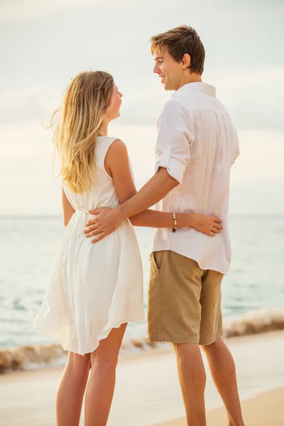 Pareja joven enamorada en la puesta de sol de la playa —  Fotos de Stock