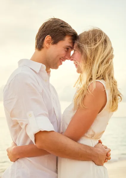 Pareja joven enamorada en la puesta de sol de la playa —  Fotos de Stock