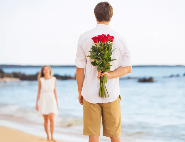 Romántico joven pareja enamorada, hombre celebración sorpresa ramo de r — Foto de Stock