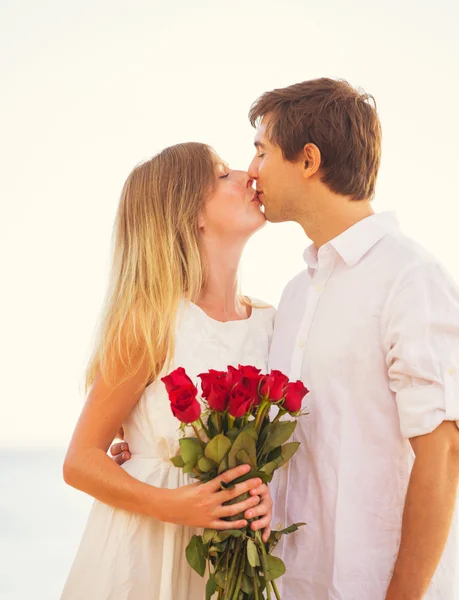 Romantic Young Couple in Love, Man holding surprise bouquet of r — Stock Photo, Image