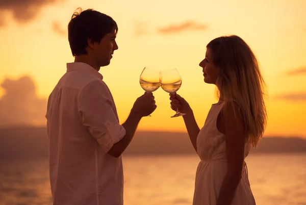 Silhouette di coppia che si gode un bicchiere di champagne sul bea tropicale — Foto Stock