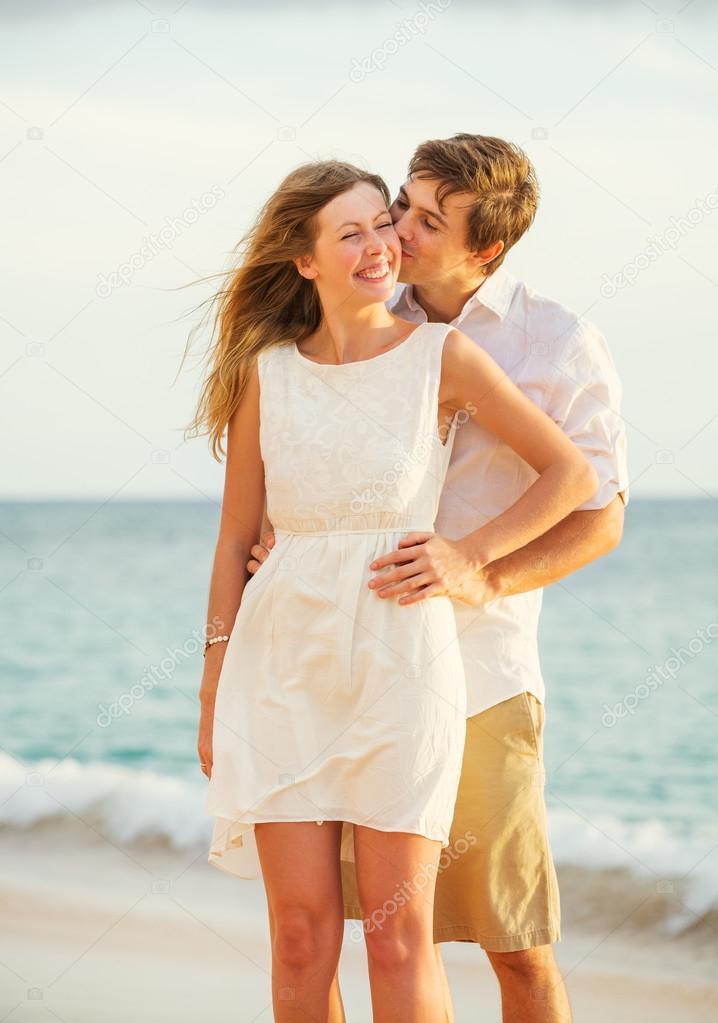 Young couple in love on the beach sunset