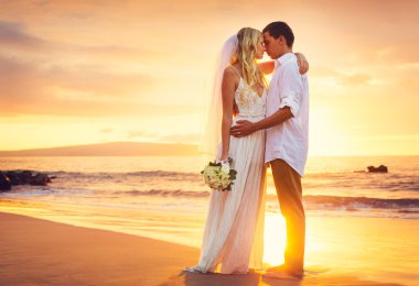 Bride and Groom, Kissing at Sunset on a Beautiful Tropical Beach clipart
