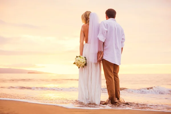 Noiva e noivo, desfrutando do incrível pôr do sol em um belo tropical — Fotografia de Stock