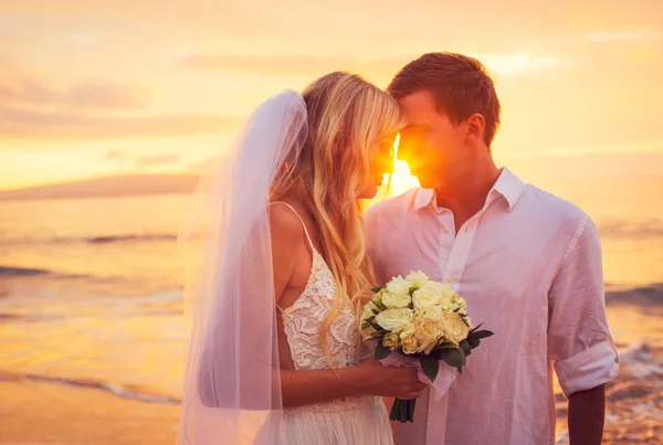 Noiva e noivo, desfrutando do incrível pôr do sol em um belo tropical — Fotografia de Stock