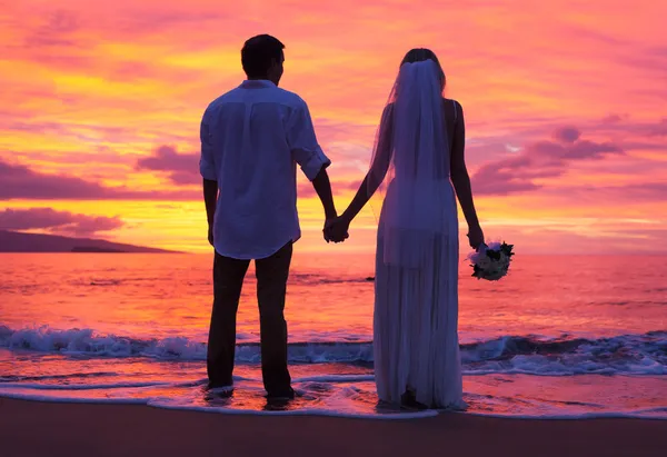 Noiva e noivo, desfrutando do incrível pôr do sol em um belo tropical — Fotografia de Stock