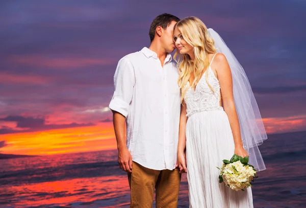 Bruid en bruidegom, genieten van geweldige zonsondergang op een mooie tropische — Stockfoto