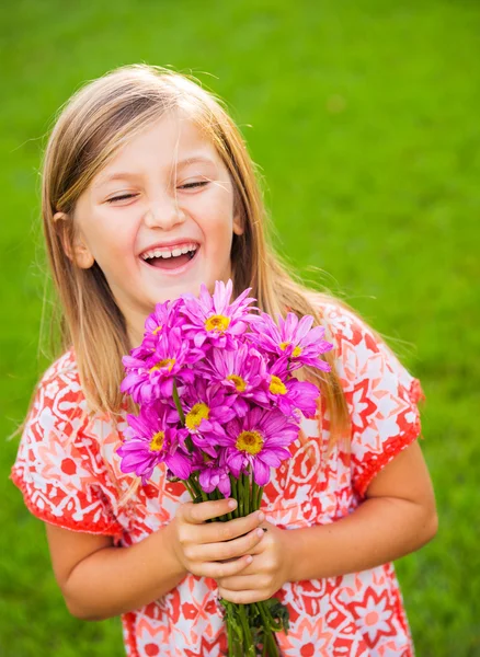 Портрет усміхненої милої дівчинки з квітами — стокове фото