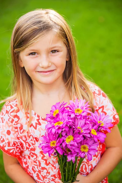 Retrato de una linda niña sonriente con flores — Foto de Stock