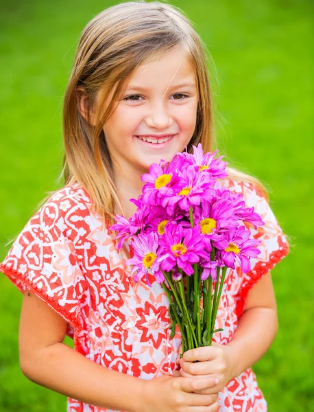 꽃과 함께 웃 고 귀여운 어린 소녀의 초상화 — 스톡 사진
