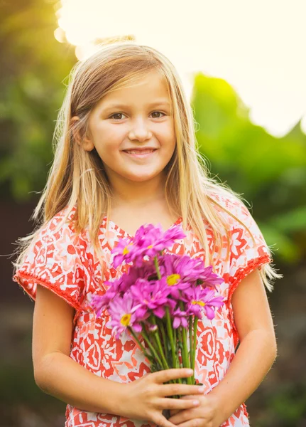 Portret uśmiechający się ładny dziewczynki z kwiatami — Zdjęcie stockowe