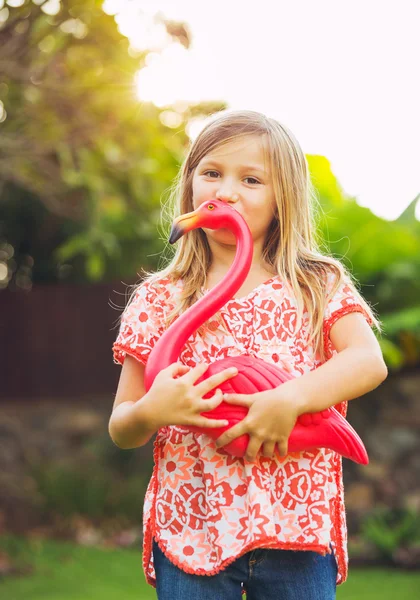 Portrait of cute little girl outside with pink flamingo — Stock Photo, Image