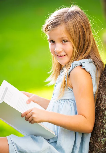 Little girl reading book outside — Stock Photo, Image