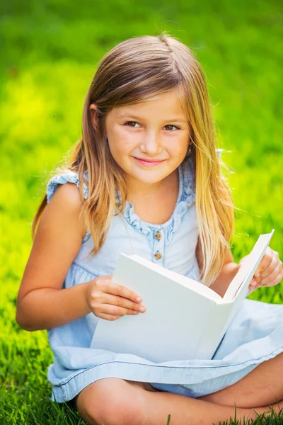 外の小さな女の子の読書 — ストック写真