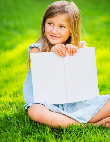 Kis lány olvasókönyv kívül — Stock Fotó