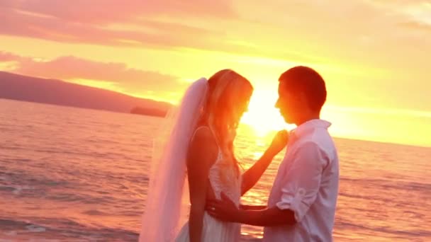Braut und Bräutigam am schönen tropischen Strand bei Sonnenuntergang