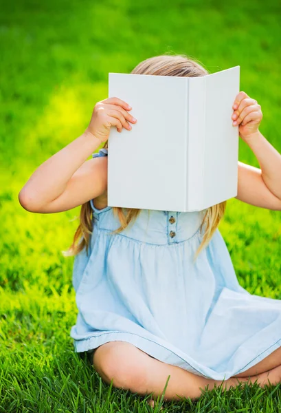Очаровательная маленькая девочка читает книгу — стоковое фото