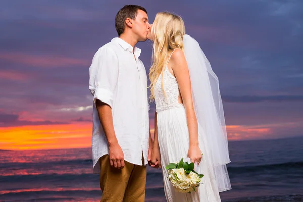 Just married couple kissing on tropical beach at sunset — Stock Photo, Image