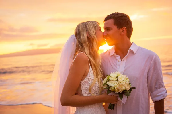 Just married couple kissing on tropical beach at sunset — Stock Photo, Image