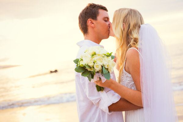 Just married couple kissing on tropical beach