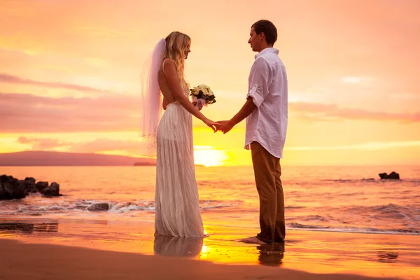 Frisch verheiratetes Paar am tropischen Strand bei Sonnenuntergang — Stockfoto
