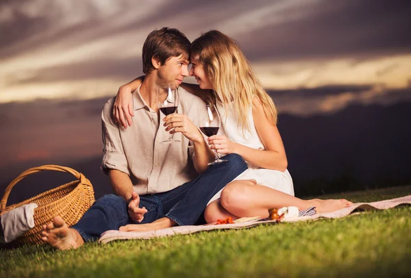 Coppia bere bicchiere di vino sul romantico picnic tramonto — Foto Stock