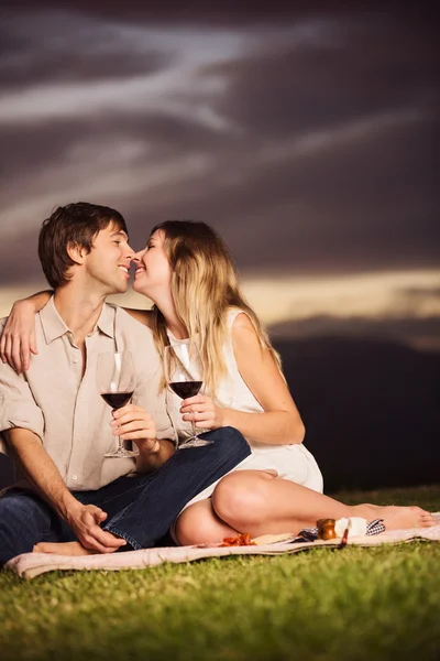 Coppia bere bicchiere di vino sul romantico picnic tramonto — Foto Stock