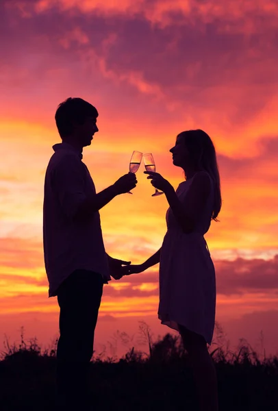 Silueta de pareja bebiendo champán al atardecer — Foto de Stock