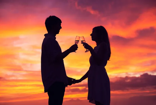 Silhouette von Paar, das Champagner bei Sonnenuntergang trinkt — Stockfoto