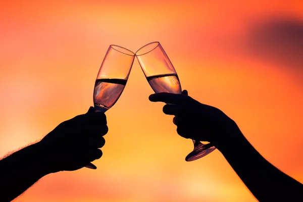 Silueta páru pití šampaňského při západu slunce — Stock fotografie