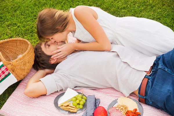 Привлекательная пара на романтическом послеобеденном пикнике целуется — стоковое фото